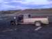 1996 Dodge 1500 - A weathered pickup truck is deeply mired in dark, wet earth, with its driver's side door ajar.