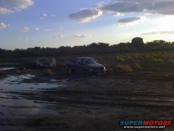 Dark blue 1996 Dodge 1500 pickup truck stuck in mud