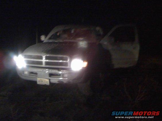 Front view of a Dodge Ram pickup truck at night, driver's side door open