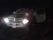 1996 Dodge 1500 - A Dodge Ram pickup truck is parked at night with its headlights and driver's side door illuminated.