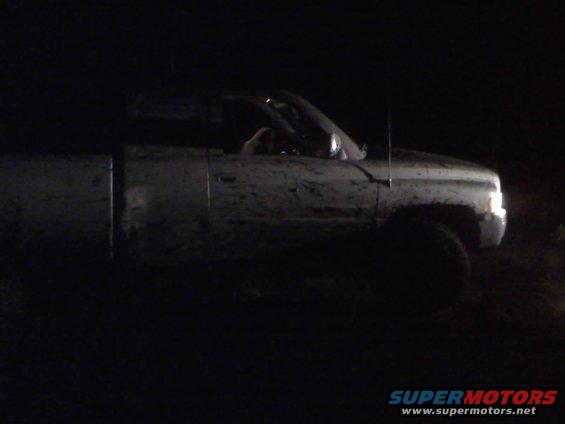 Mud-splattered 1996 Dodge 1500 pickup truck, 3q front view at night