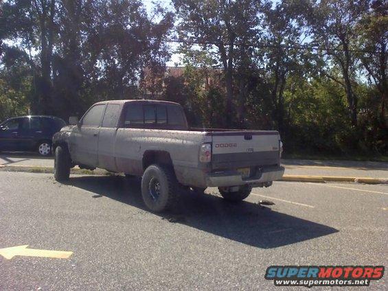 Dodge Ram pickup truck parked on asphalt with trees in background