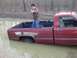 1996 Dodge 1500 - This 1996 Dodge 1500 is stuck deep in the mud with a person standing in the truck bed.