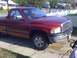 1996 Dodge 1500 - This red 1996 Dodge 1500 pickup truck is shown from a 3q-front angle, with a "For Sale" sign visible in the driver's side window.