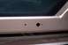 1996 Ford Bronco - This image shows the rear bumper area of a vehicle, with holes for a license plate light assembly.