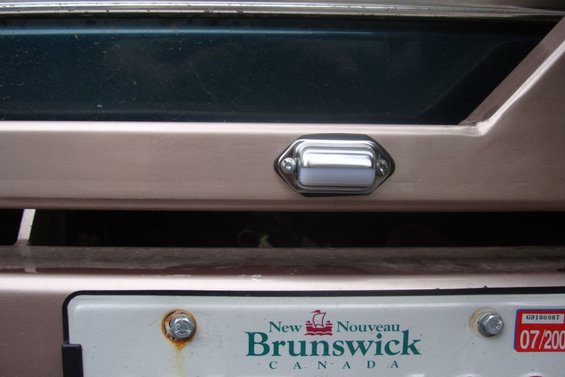 License plate light above a New Brunswick license plate with a 07/2007 expiry sticker