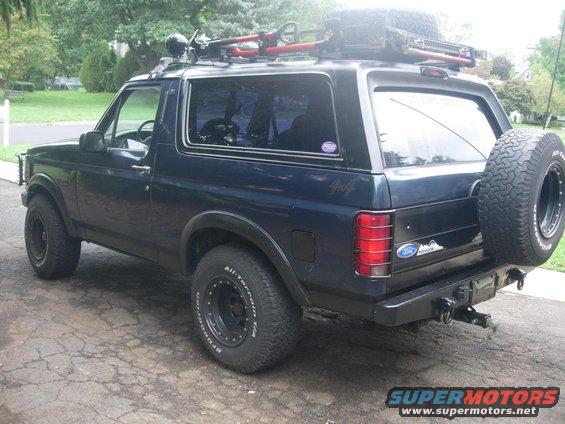 Black 1993 Ford Bronco, rear view, with roof rack and spare tire mounted on the tailgate