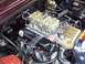 1963 Ford Galaxie - Close-up view of a V8 engine a triple carburetor setup and custom valve covers.