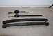 1996 Ford Bronco - Two driveshafts and two leaf springs, likely for a vehicle, are laid out on a concrete surface.
