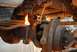 1996 Ford Bronco - Mechanic uses a torch on a rusty vehicle suspension part, creating sparks.