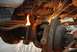 1996 Ford Bronco - Mechanic uses a cutting torch on a rusty vehicle suspension part, creating a shower of sparks.