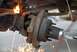 1996 Ford Bronco - Close-up of a rusted vehicle suspension part being worked on with a torch, creating a shower of sparks.