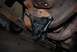 1996 Ford Bronco - Close-up of a vehicle's suspension component attached to a heavily rusted frame.