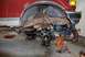 1996 Ford Bronco - The suspension and chassis of a red 1996 Ford Bronco are visible as it undergoes repair work.