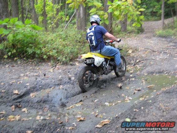 Yellow 1993 Suzuki RMX250 side view on muddy trail