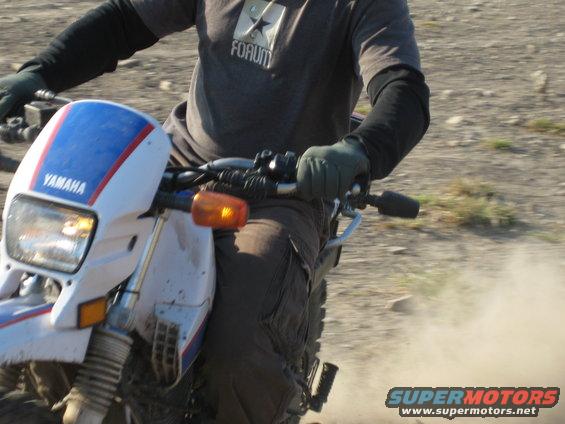 Motorcycle with white front fairing and blue and red stripes, "YAMAHA" visible