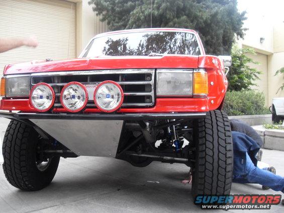 Red truck with off-road lights and suspension work being done