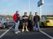 2001 Ford Mustang - A group of men pose for a photo in a parking lot, with two Ford Mustangs visible in the background.