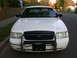2000 Ford Crown Victoria - Front view of a white 2000 Ford Crown Victoria police car parked on a residential street.