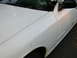 2000 Ford Crown Victoria - The front fender of a white sedan shows signs of wear, including rust and minor scratches.