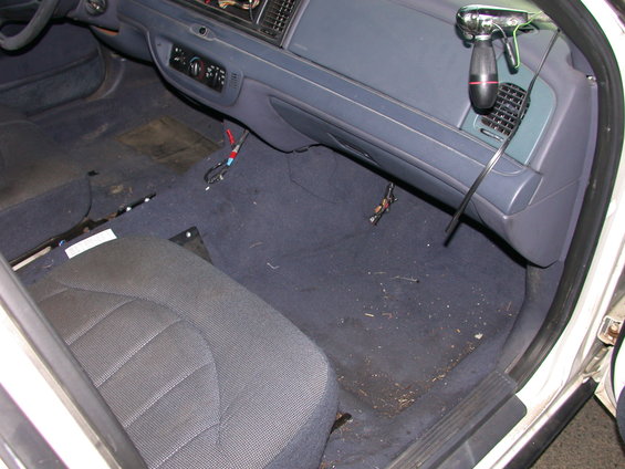 Interior of a 2000 Ford Crown Victoria showing the driver's side seat, dashboard, and floor