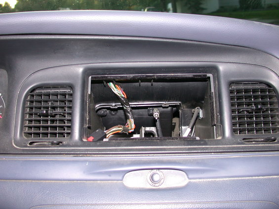 Interior dashboard of a 2000 Ford Crown Victoria with an open radio slot and exposed wiring