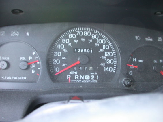 Car dashboard with speedometer, odometer showing 136891 miles, fuel gauge, and temperature gauge