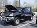 2001 Ford Mustang - A black Ford F-150 pickup truck is displayed with its hood and driver door open.