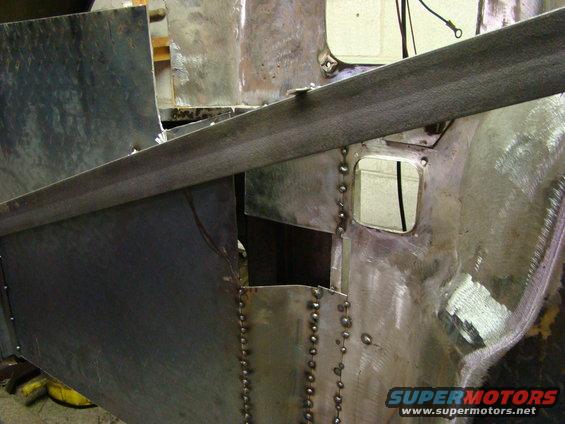 close-up of metal body panels being welded and repaired, showing rivets and seams