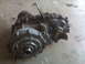 1994 Jeep Cherokee - A silver and black transfer case is shown from a side angle on a concrete surface.