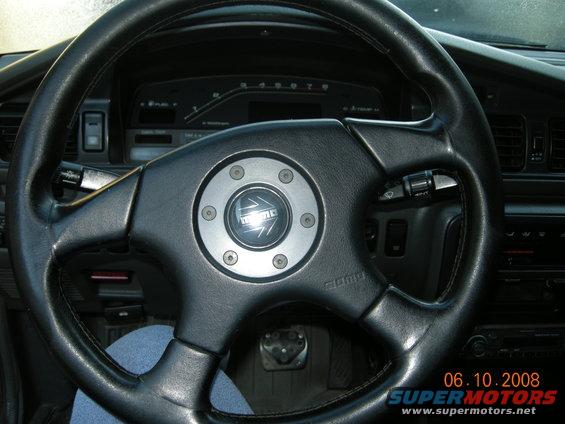 Interior view of a car showing a MOMO steering wheel and dashboard gauges. Date stamp reads 06.10.2008