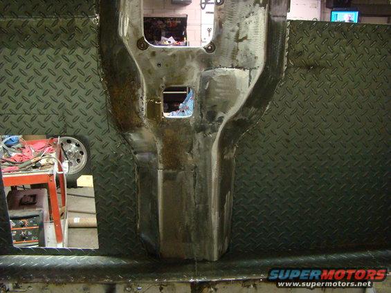Vehicle chassis undergoing repair with diamond plate metal panels and visible welding marks