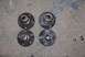 1996 Ford Bronco - Four used wheel hubs are laid out on a concrete surface, showing signs of rust and wear.