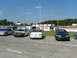 1993 Ford Taurus - Several sedans are parked at a racetrack on a sunny day.
