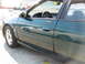 1993 Ford Taurus - The side of a green sedan is shown, with a reflection of its wheel in the door panel.