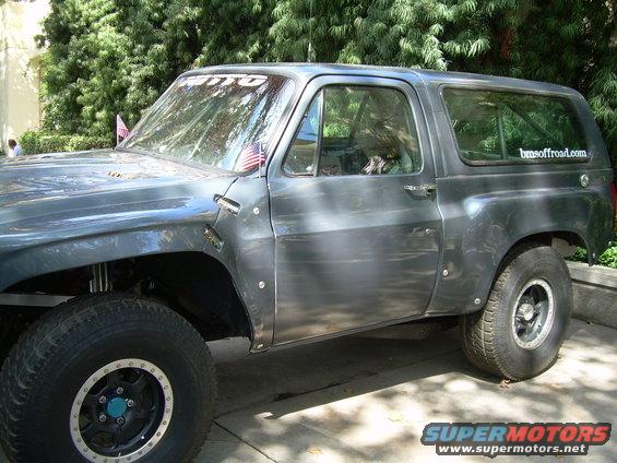 Modified SUV with off-road tires and fender flares. Sticker on rear window reads 'bmsoffroad.com'