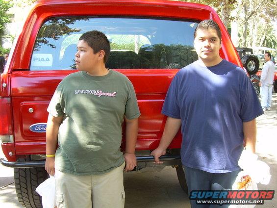 Red 1986 Ford Bronco rear view with two people standing next to it