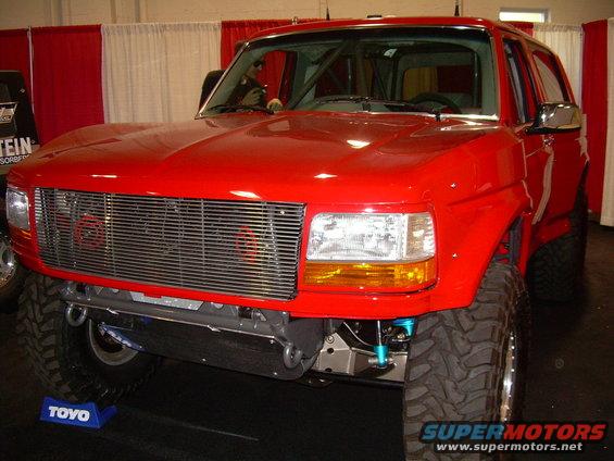 red Ford Bronco with custom grille and roll cage