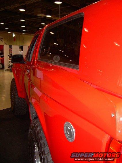 Red SUV side view with large tires and a fuel cap