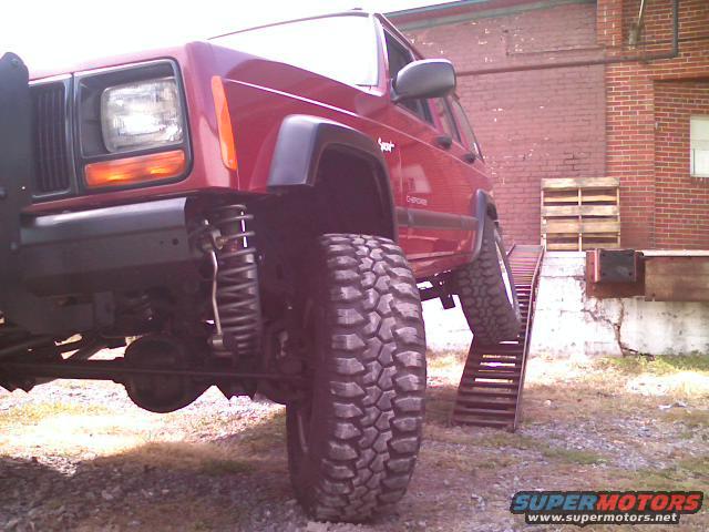 Red 1998 Jeep Cherokee on a metal ramp
