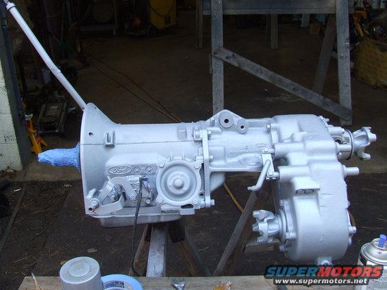 Ford transmission and transfer case assembly painted silver, resting on sawhorses