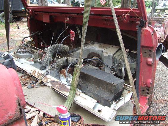 Disassembled vehicle interior showing heater core, ducting, and wiring. WD-40 can visible