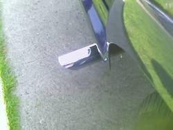 Close-up of chrome trim piece attached to a car door edge