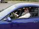 2001 Ford Mustang - A blue 2001 Ford Mustang coupe is seen from the side with two men inside, one driving and the other looking at a document.