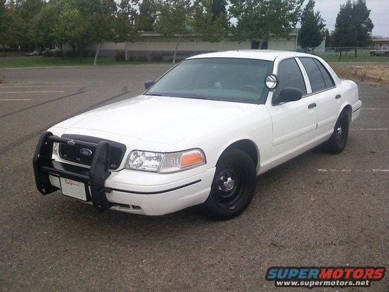 White 2000 Ford Crown Victoria with push bumper and spotlight