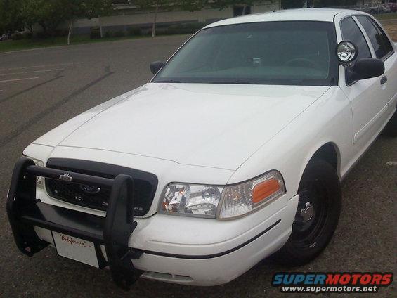White 2000 Ford Crown Victoria police car, front quarter view, with push bar and spotlight