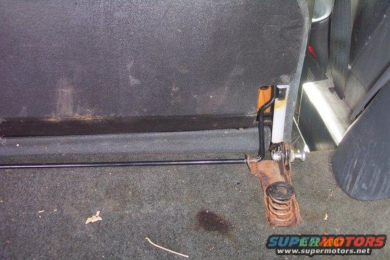 Back seat latch mechanism with spring and metal rod