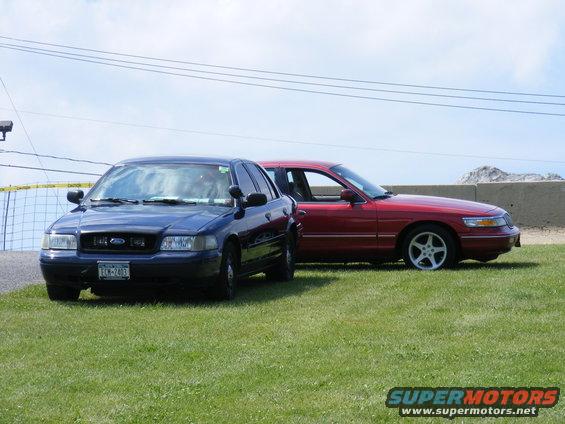 Red sedan with a silver five-spoke wheel and a blue sedan with a license plate