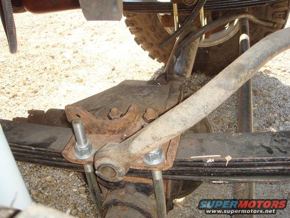 Rusty leaf spring assembly with U-bolts and shock absorber mount
