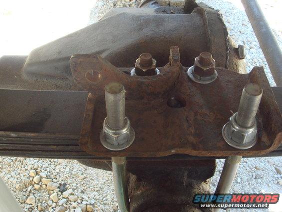 Rear axle leaf spring U-bolt plate with rusty mounting hardware